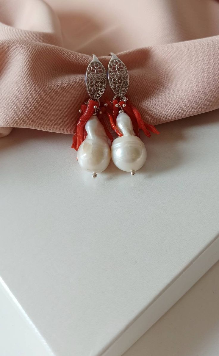 Bride earrings made of: - Baroque Pearl (12 mm), white color; - Bamboo Coral chips, red color; - 925 Sterling Silver hook with filigree. Lenght : 4 cm / 1,57 inches * SHIPPING * Your order will be shipped within 1-3 business days from your purchase. You can choose between 2 shipping methods: STANDARD MAIL (NOT TRACEABLE) It is a cheap and fast shipping method, but NOT TRACEABLE. Chapeau Atelier is not responsible for any postal disruptions, delays or losses. REGISTERED MAIL (TRACEABLE) It is an Celebration White Sterling Silver Bridal Earrings, White Sterling Silver Bridal Earrings For Celebration, Sterling Silver Bridal Earrings For Celebration, Sterling Silver White Bridal Earrings For Celebration, Red Filigree Dangle Earrings, White Filigree Jewelry For Gifts, Elegant Handmade Red Earrings, White Sterling Silver Jewelry For Celebration, White Pearl Dangle Clip-on Earrings