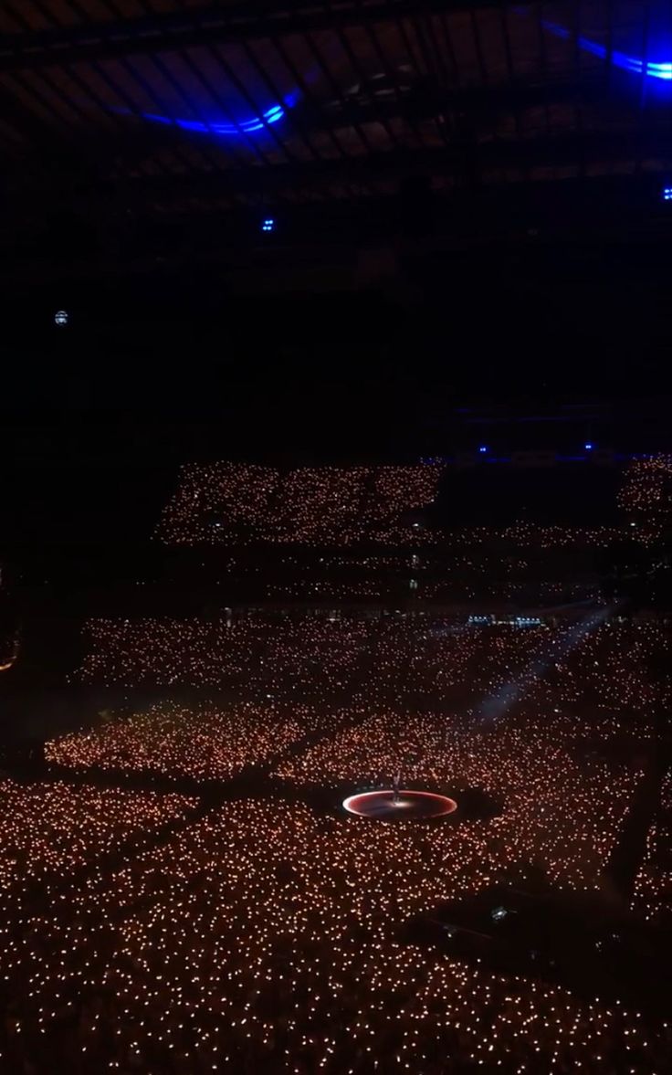 a large group of people in the middle of a room with lights all over them