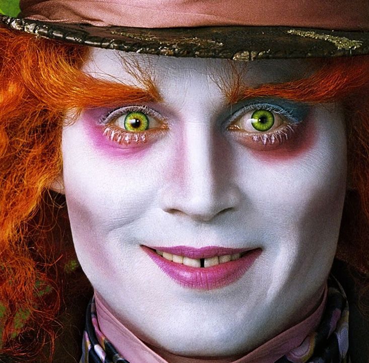 a close up of a person with red hair and green eyes wearing a top hat