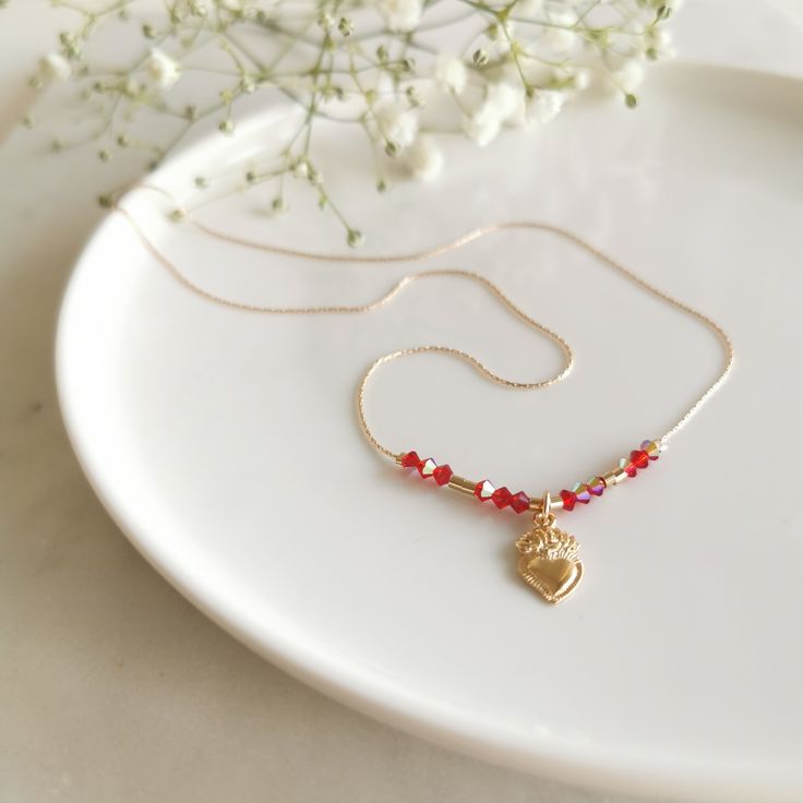 Delicado collar corto hecho de una delgada cadena Gold Filled de 14k con cuentas de cristales rojos y un colgante de Sagrado Corazón ♡ Simple pero elegante, este collar es una pieza de acento sutil, adorable por sí mismo y es un hermoso regalo. Materiales: Relleno de oro de 14k Sin níquel y sin plomo ♡ Hecho a mano con amor en Suiza ♡ Más diseños, visite mi sitio: www.ianalo.ch ♡ Instagram: @ianalojewelry TU - COLLAR - Cadena aprox.45cm - Cadena llena de oro de 14k. - Cuentas de Cristales facetados. - Piedras Naturales. 1 4 K - G O L D - F I L L E D - B E N E F I T S - Alternativa asequible al oro macizo. - Contienen 100 veces más oro real que el chapado en oro y son muy duraderos y resistentes al deslustre. - Alta calidad para uso y durabilidad de por vida. - El acabado 14k Gold-Filled es Adjustable Gold-plated Heart Necklace, Adjustable Heart-shaped Gold-plated Necklace, Adjustable Gold Plated Heart Necklace, Adjustable Heart-shaped Gold Plated Necklace, Dainty Heart Beads Pendant Jewelry, 14k Gold Filled Pendant Necklace For Valentine's Day, Dainty Heart Pendant Birthstone Necklace, Adjustable Gold Plated Necklaces With Heart Charm, Delicate Crystal Necklaces With Tiny Beads For Gift