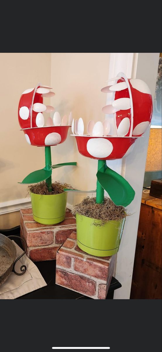 two red and green flower pots sitting on top of each other