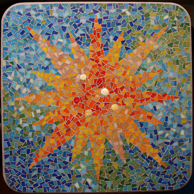 a colorful mosaic tile wall hanging on the side of a building with an orange and yellow sun