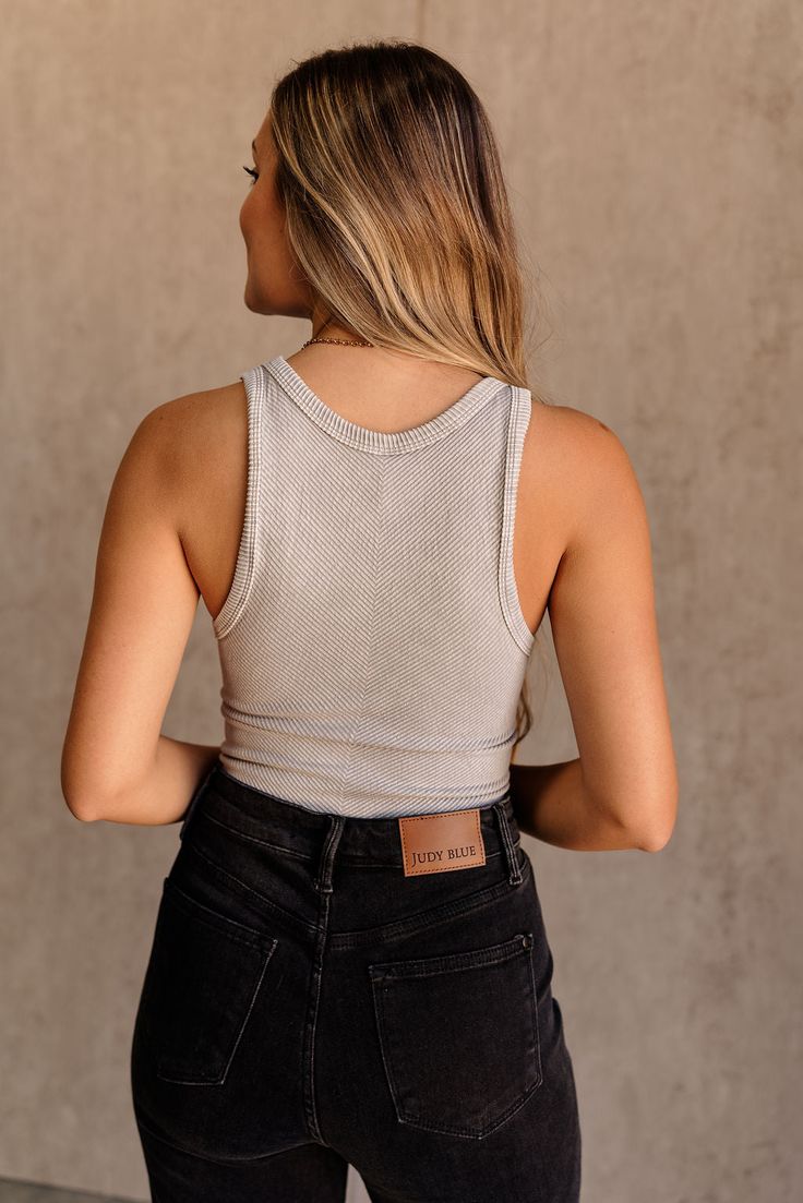 Introducing the On Repeat Brami in Grey, a staple piece for your everyday wardrobe. Made from ribbed grey fabric, this brami features a flattering cropped waist that pairs perfectly with high-waisted bottoms. The thick straps provide comfortable support, while the round neck adds a classic touch. Versatile and stylish, the On Repeat Brami is perfect for layering or wearing on its own for a chic, effortless look. Chic Gray Stretch Crop Top, Trendy Gray Cropped Crop Top, Chic Ribbed Crop Top With Tank Straps, Trendy Seamless Gray Crop Top, Everyday Ribbed Cotton Crop Top, Trendy Gray Seamless Crop Top, Trendy Tank Straps Crop Top For Loungewear, Chic Crop Top With Tank Straps, Chic Crop Top With Tank Straps For Everyday