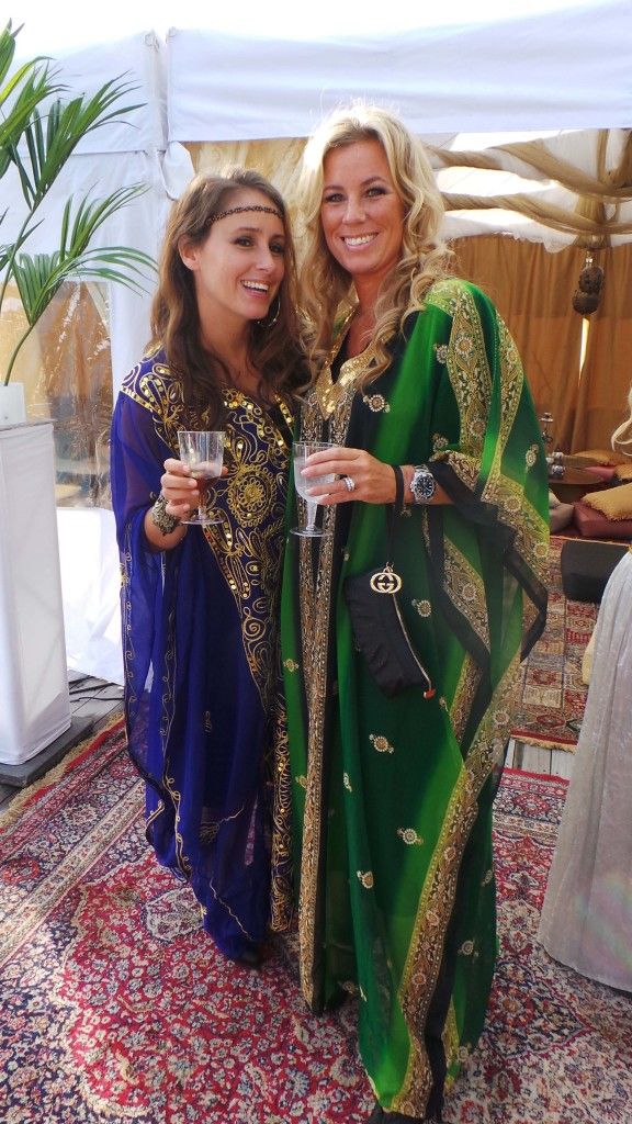 two women standing next to each other holding wine glasses