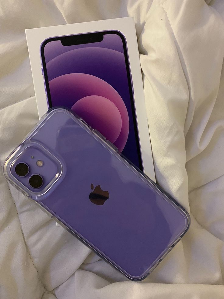 an iphone case sitting on top of a bed next to a box with the phone in it