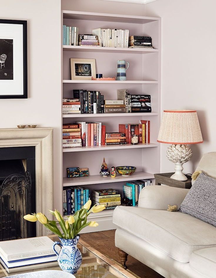 a living room filled with furniture and a fire place in front of a book shelf