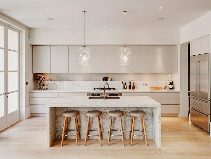 a kitchen with marble counter tops and stools next to an island in the middle