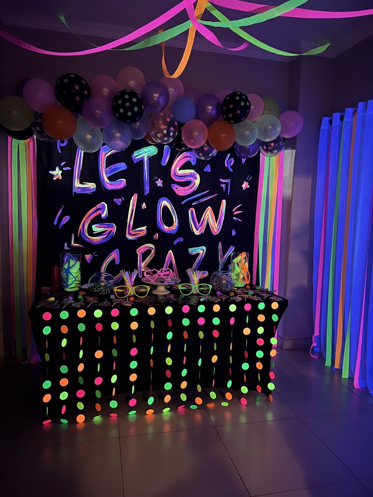 a party with balloons, streamers and neon lights on the wall that says let's glow crazy