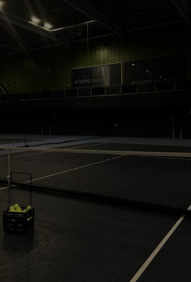 the tennis court is empty and ready to be played at night or in the dark