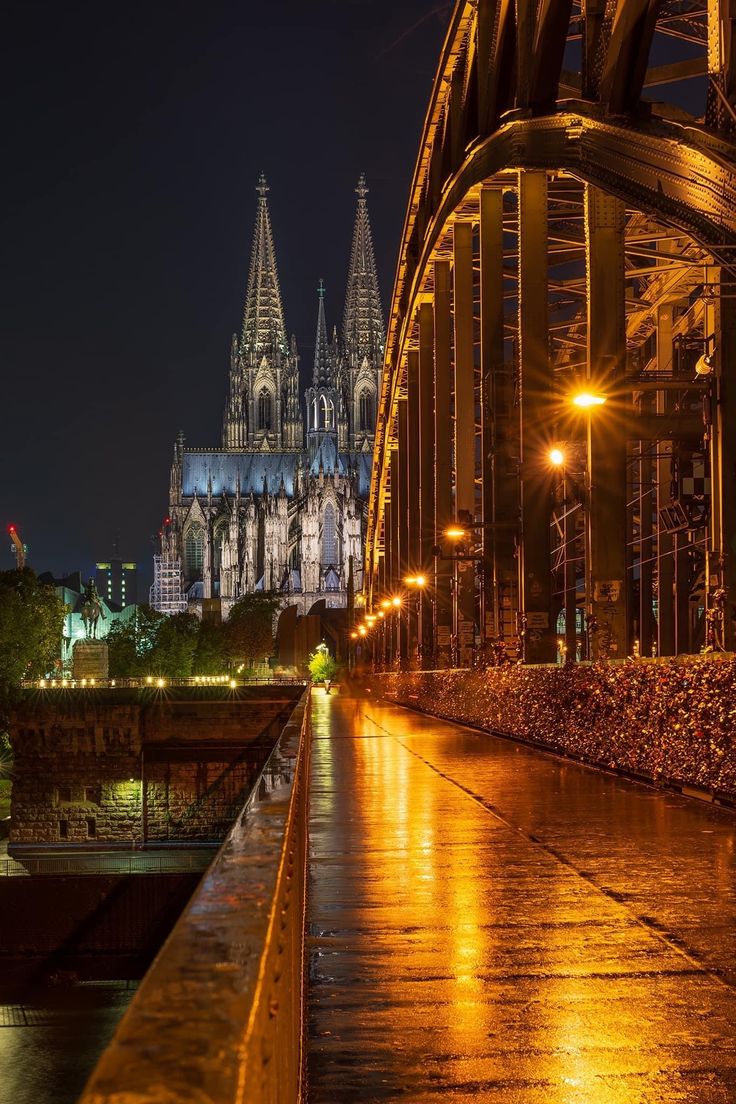 the cathedral is lit up at night with lights on