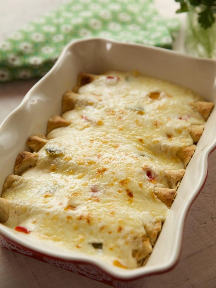 a casserole dish with meat and cheese in it sitting on a wooden table