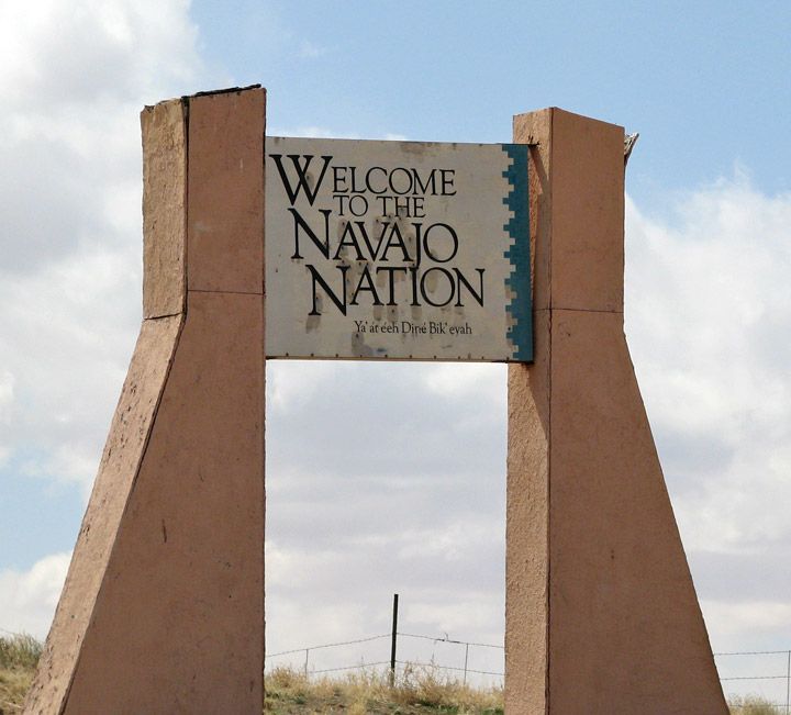 a welcome sign for the navajo nation in front of a fence