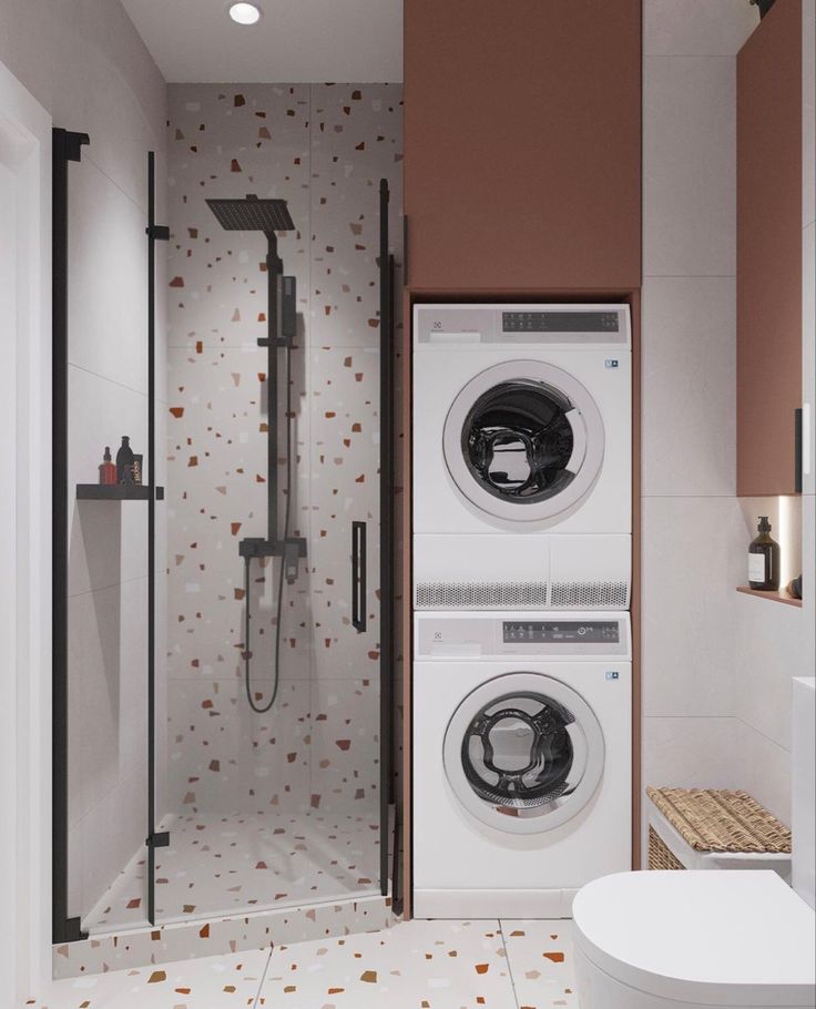 a washer and dryer in a bathroom next to a toilet with a shower