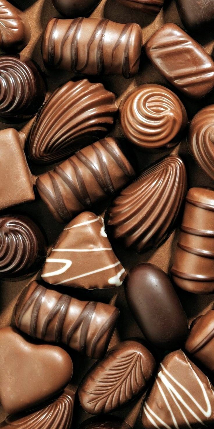 many chocolates are arranged together in a pile