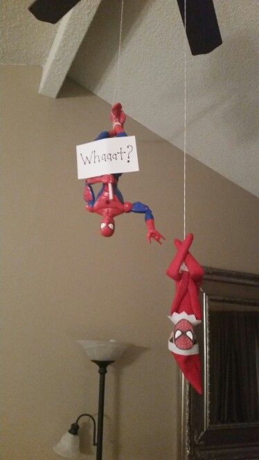 a spiderman mobile hanging from the ceiling with a sign that says what's up?