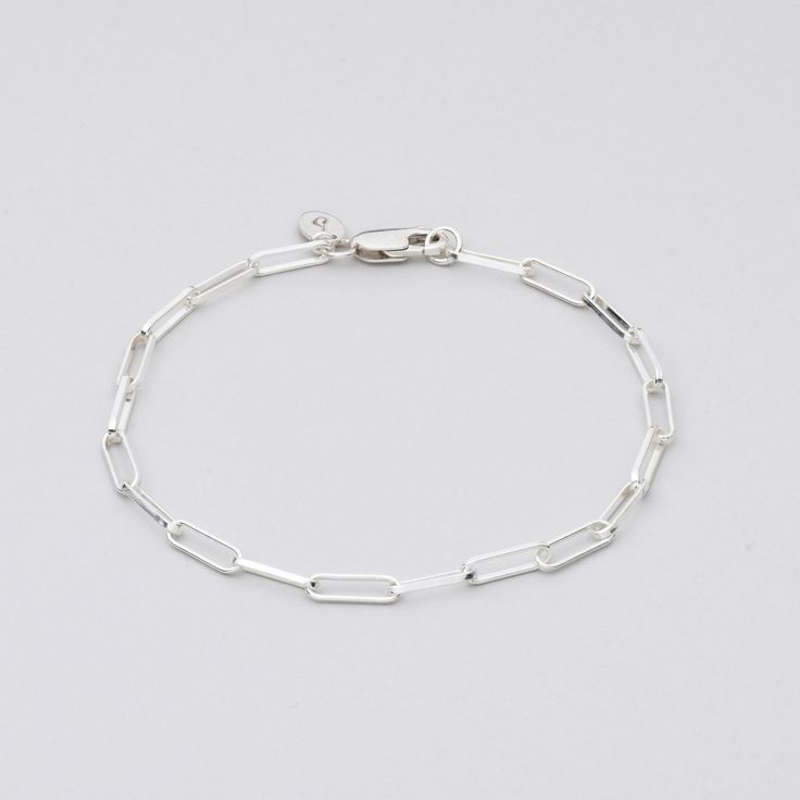 Sterling Silver bracelet on grey background Classic Silver Chain Bracelet For Everyday, Elegant Silver Chain Paperclip Bracelet As Gift, Sterling Silver Link Bracelets With Paperclip Chain, Sterling Silver Bracelets With Paperclip Chain, Minimalist Silver Chain Bracelet In Paperclip Shape, Gift Sterling Silver Link Bracelet With Paperclip Chain, Classic Sterling Silver Bracelet For Everyday, Modern Silver Paperclip Bracelet With Oval Links, Classic Silver Paperclip Bracelet With Box Chain