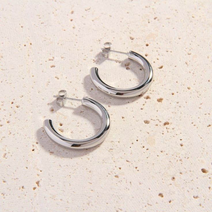 Stock your jewelry box with our new, better-than-basic Bijou Cali Silver Hoops. These lovely silver hoop earrings are slightly smaller than our classic Cali Silver Hoops. They’ll look amazing with your favorite silver jewellery pieces. Perfectly weighted and designed with simple and clean lines, these dainty hoops are an essential day-to-night accessory. We love wearing the Bijou Cali Hoops with a lace blouse and tailored slacks for daytime events, or pairing them with a flirty going-out dress a Classic Hypoallergenic Silver Huggie Earrings, Minimalist Earrings With Shiny Finish For Everyday, Minimalist Polished Silver Huggie Earrings, Silver Small Hoop Minimalist Earrings, Minimalist Shiny Finish Earrings For Everyday, Minimalist Silver Huggie Earrings With Polished Finish, Minimalist Shiny Earrings For Everyday Wear, Minimalist Everyday Earrings With Shiny Finish, Modern Silver Metal Huggie Earrings