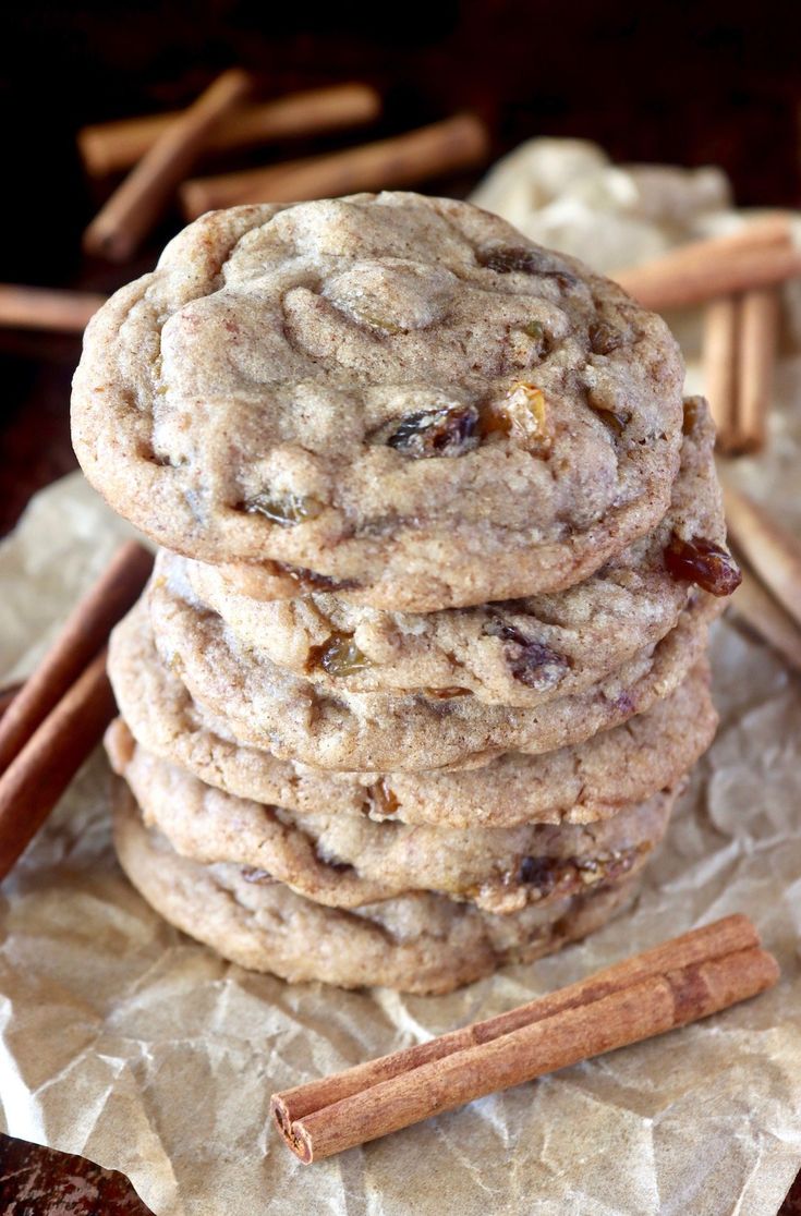 a stack of cookies sitting on top of a piece of wax paper next to cinnamon sticks