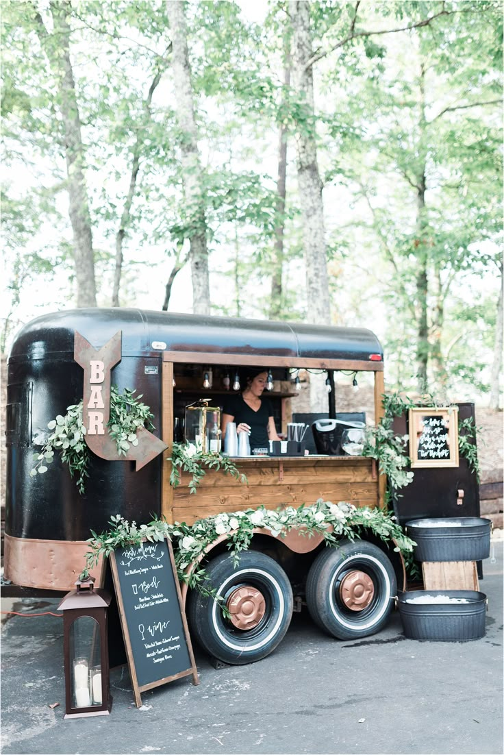 an old fashioned truck is decorated with greenery and chalkboard writing on the side