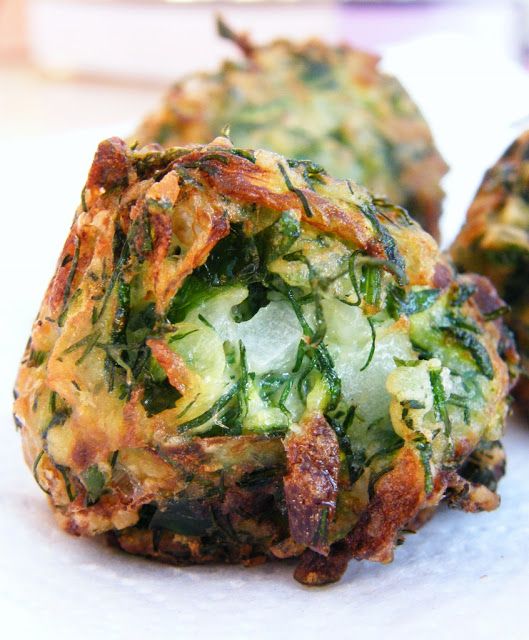 two vegetable fritters sitting next to each other on a white tablecloth covered surface