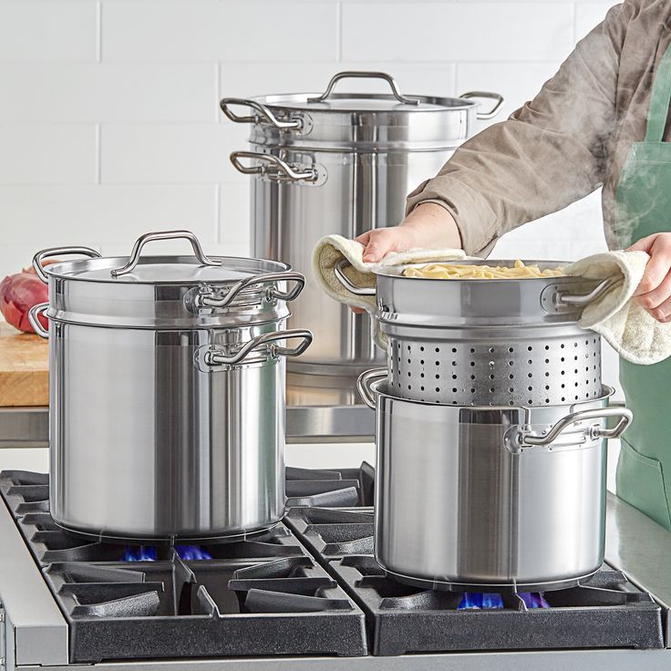 a woman is cleaning pots on the stove