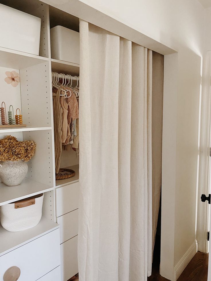 an open closet with clothes hanging on the rack and other items in front of it