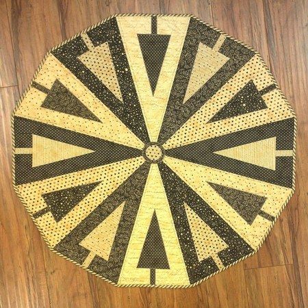 a close up of a black and yellow rug on a wooden floor