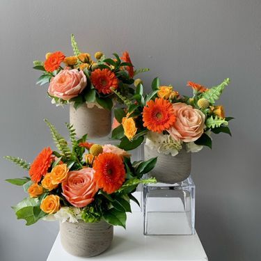 three vases filled with flowers on top of a white table