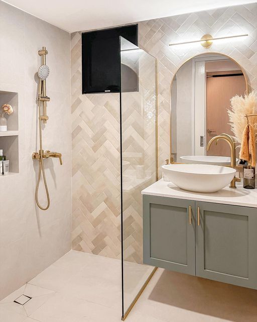 a bathroom with a sink, mirror and shower head in the corner next to it