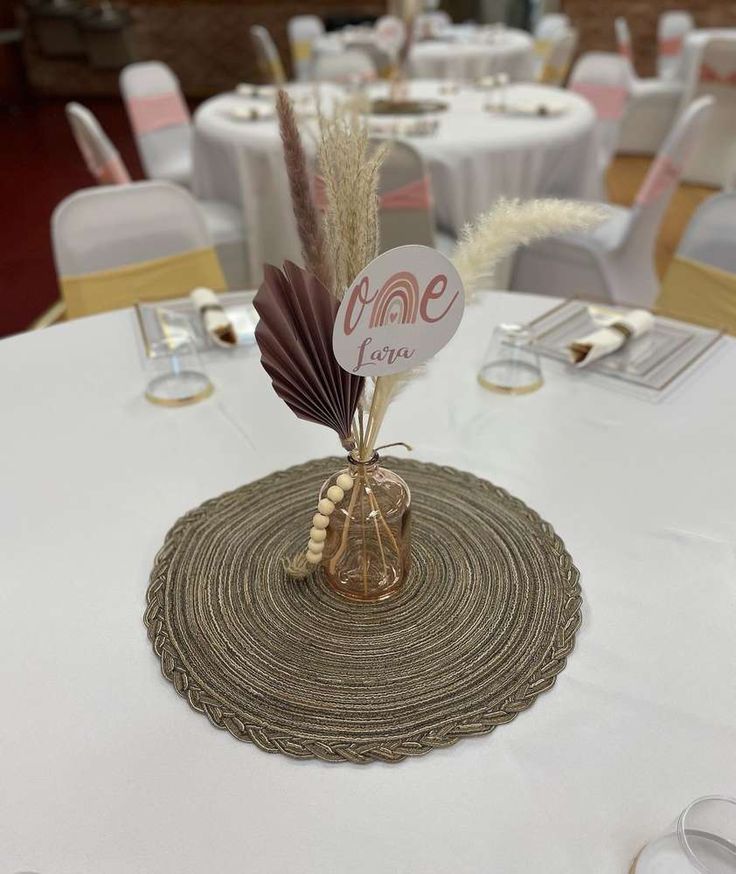 the table is set with white linens and gold place settings