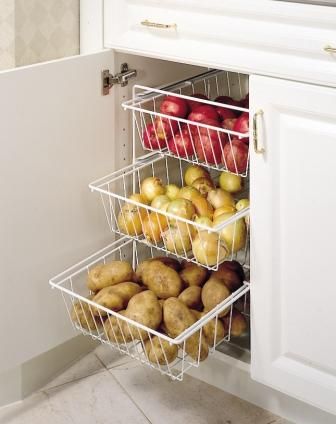 an open refrigerator door with apples and pears in baskets on the bottom shelf next to it