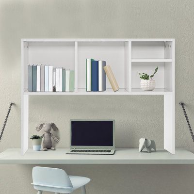 a laptop computer sitting on top of a white desk next to a book shelf filled with books