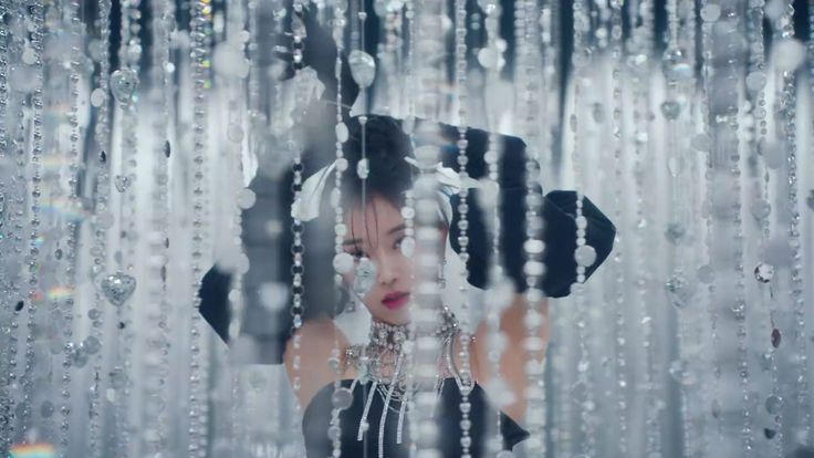 a woman standing in front of a window covered in rain