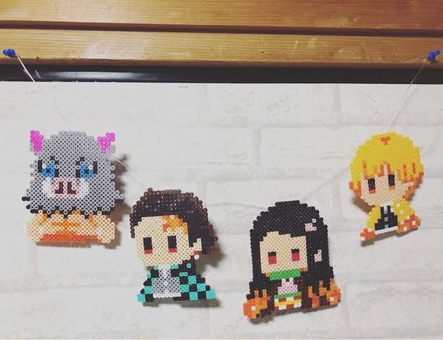 four pixelated avatars hanging on a wall next to a wooden table with pegs