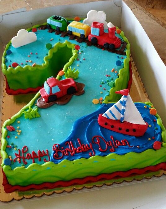 a birthday cake in the shape of a boat and train is sitting on a table