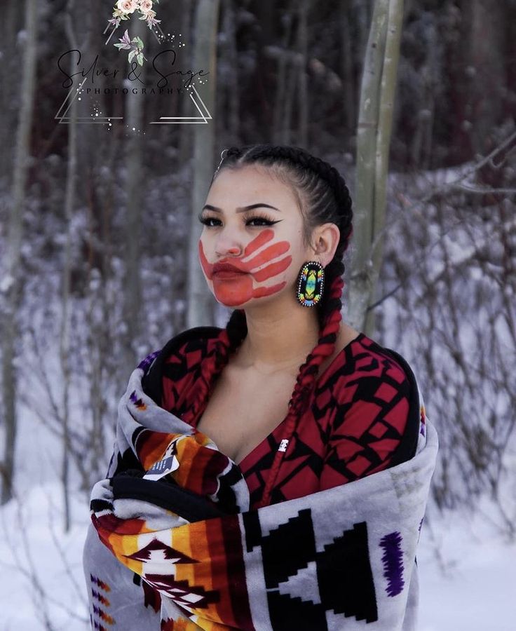 a woman with painted face standing in the snow