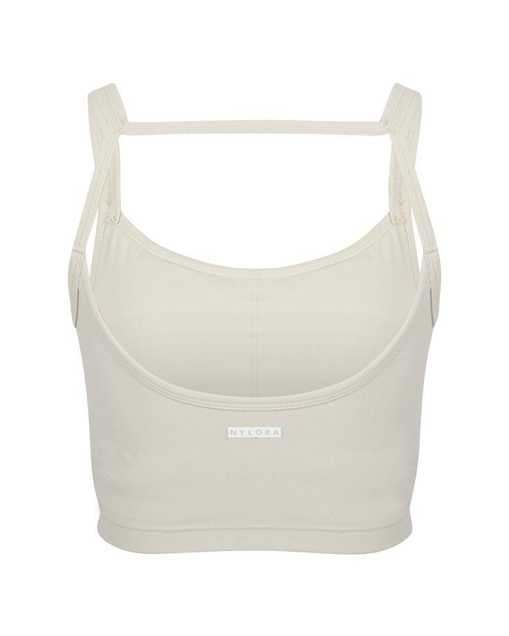 The SARA TOP in BONE by Nylora is a classic tank top made with their signature 4-way stretch rib fabric. Featuring an open back detail and a built-in shelf bra with removable padding, this top offers both style and functionality. Perfect for any active lifestyle, this top provides comfortable support and a flattering fit. DETAILS: Open back detail top Nylora's signature 4-way stretch rib fabric Built-in shelf bra with removable padding 77% Nylon, 23% Spandex Machine wash SIZE & FIT: Fits true to Sports Tank Top With Built-in Bra And Minimal Stretch, Sports Tops With Built-in Bra And Minimal Stretch, Sporty Crop Top With Built-in Bra And Minimal Stretch, Sporty Tops With Built-in Bra And Minimal Stretch, Everyday Tank Top With Built-in Bra And Medium Support, Everyday Sleeveless Sports Bra With Built-in Bra, Sporty Crop Top With Built-in Bra And Wide Straps, Sporty Tank Top With Adjustable Straps For Everyday, Functional Seamless Tank Crop Top