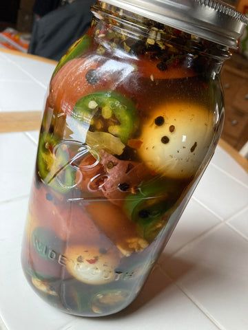 a jar filled with lots of different types of food on top of a white table