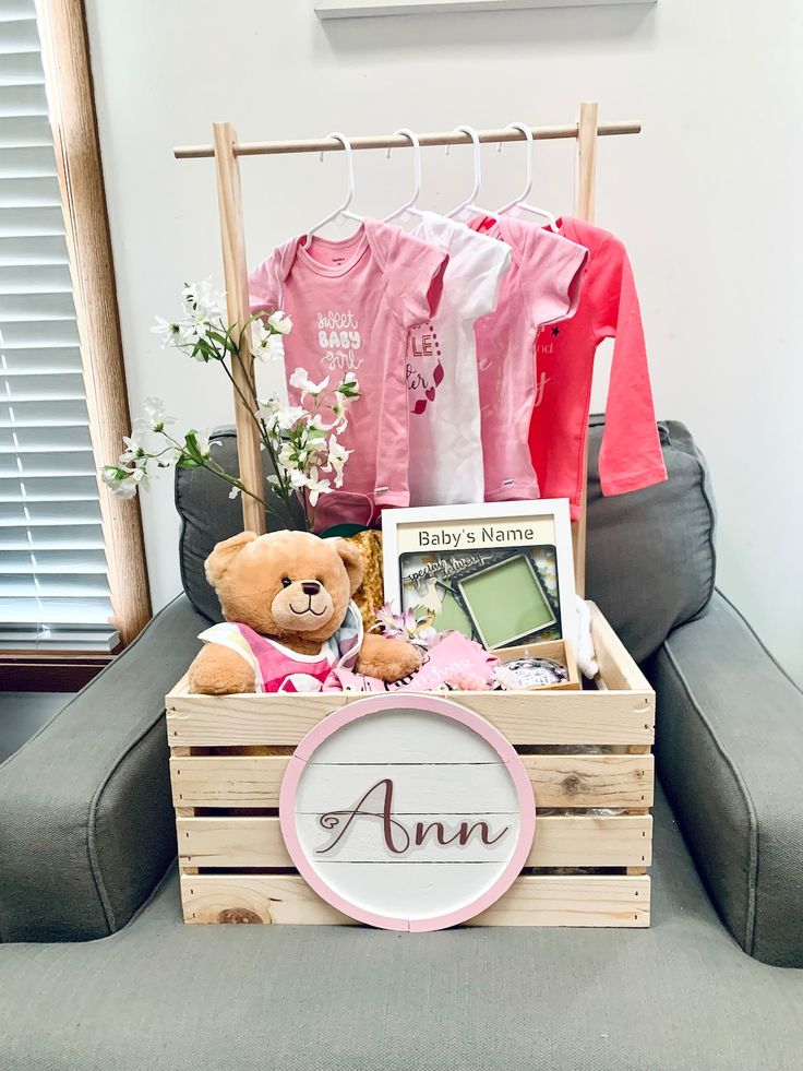 a teddy bear sitting on top of a wooden crate filled with clothes and other items