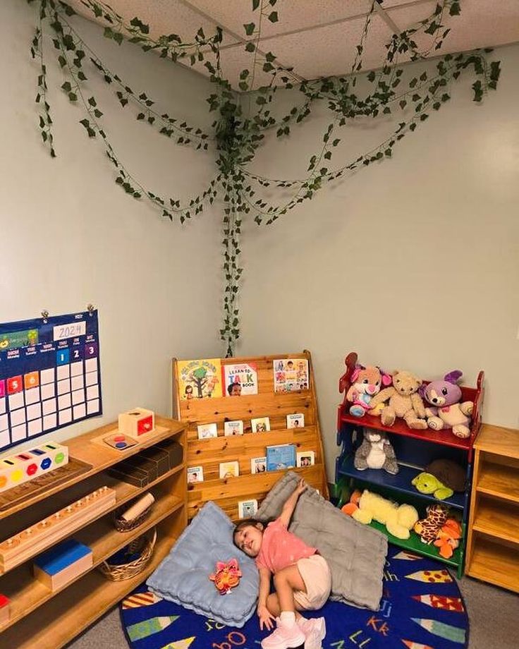 a child is laying on the floor in a room with stuffed animals and bookshelves