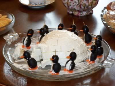 there is a cake decorated with ducks on the table and plates full of food in the background