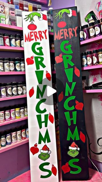 two large christmas signs are on display in a store, one is green and the other is red