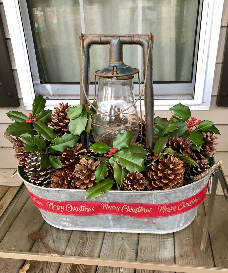 a metal bucket filled with pine cones and greenery