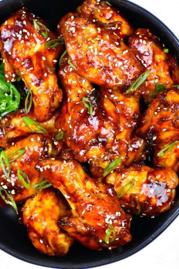 chicken wings with sesame seeds in a black bowl