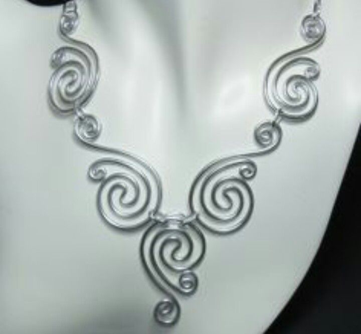 a white mannequin with a silver necklace on it's neck and ear rings