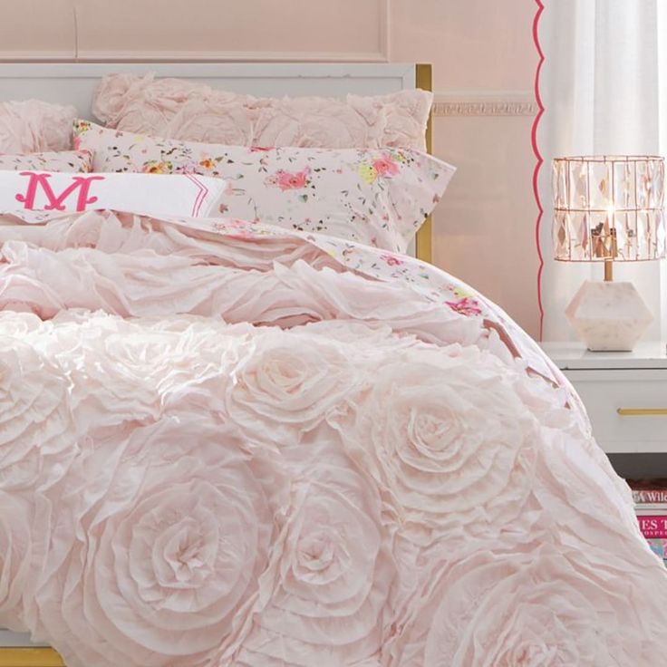 a bed with pink flowers on it in a bedroom