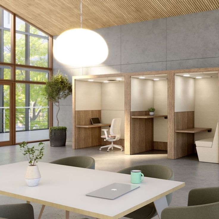 an empty office with desks, chairs and laptop computer on the table in front of large windows