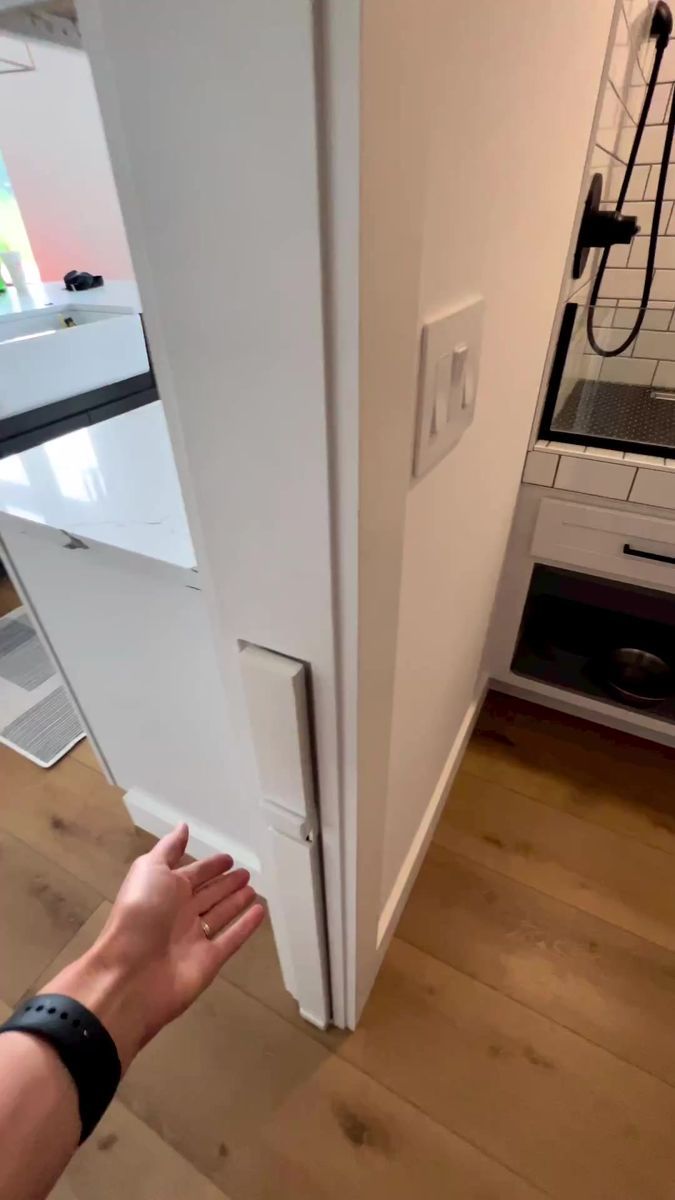 a person reaching into a refrigerator door to open it with their hand on the handle