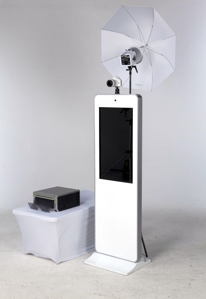 an electronic device is on display in front of a white stand with an umbrella over it