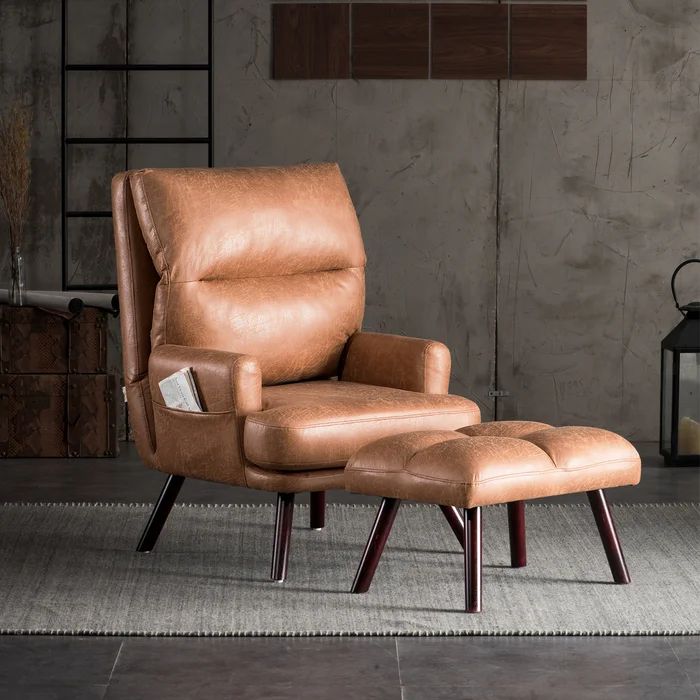 a brown leather chair and footstool in front of a gray wall with a lantern